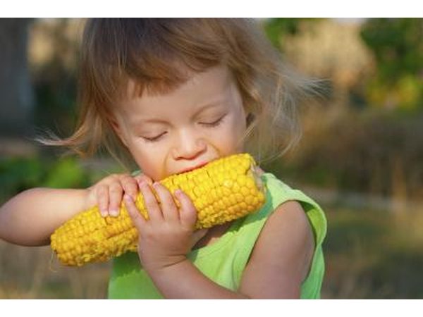 Little girl eating corn