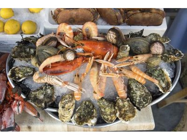 Oysters, crab, lobster and shrimp on a bucket of ice in a seafood market.
