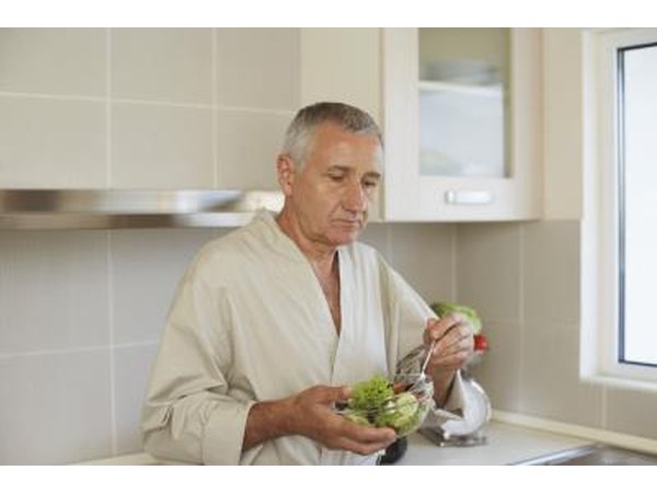 An older man eats a small salad.