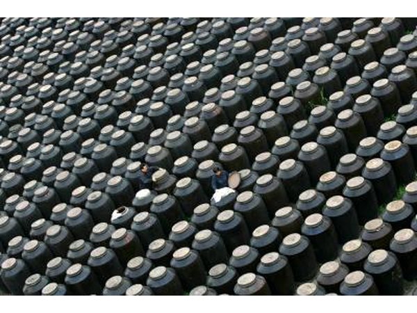 Workers inspect vinegar tanks in fermentation room of vinegar factory