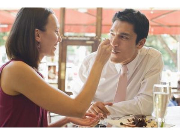 A couple sharing food in a restaurant.