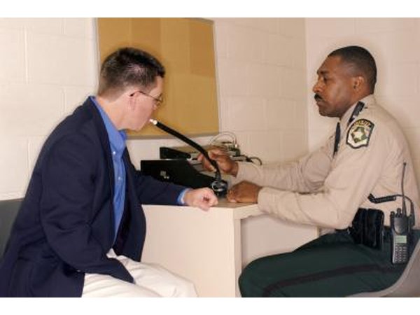 man using breathalyzer in police station