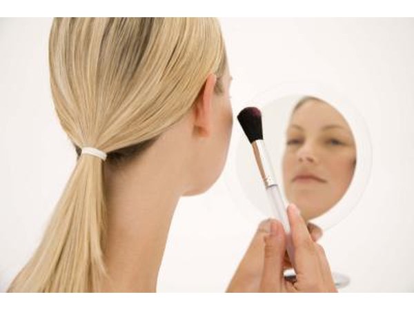 blonde woman applying makeup