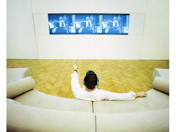 Man relaxing at home watching a plasma screen