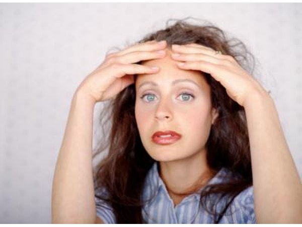 Young woman looking stressed out- hands on her forehead.