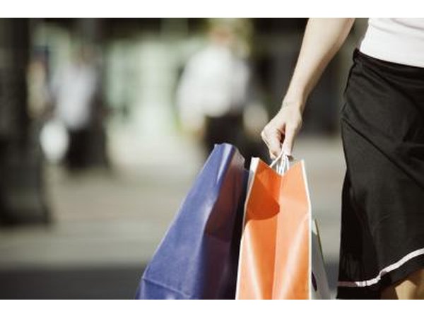 A woman walks and carries shopping bags.