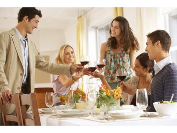 Adults toasting at a dinner party.