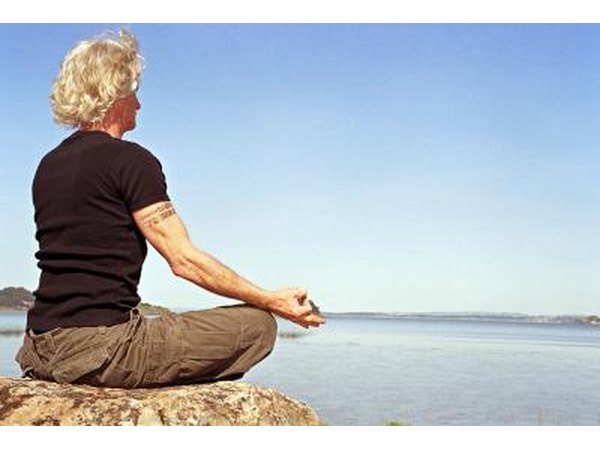 man meditating on rock