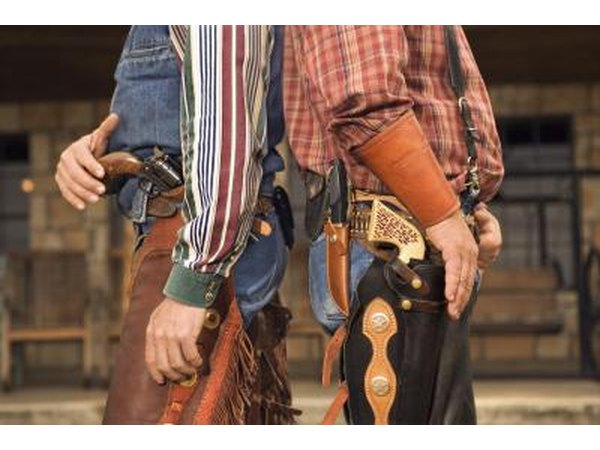Two men dressed as cowboys standing back to back