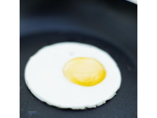 An egg fries in a pan.