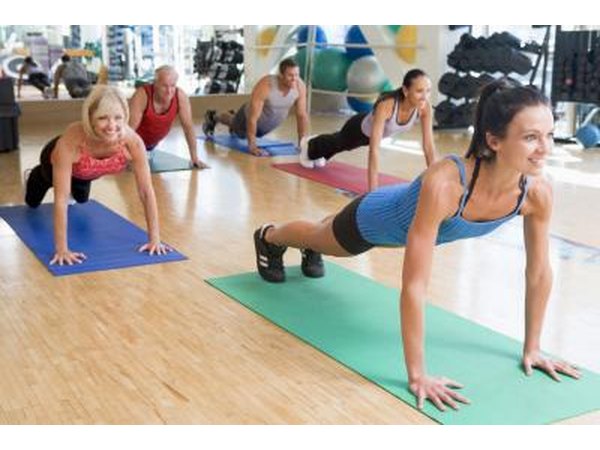 An exercise class holding plank pose in a studio.
