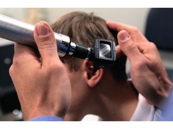 Doctor examining patient's ear with an otoscope