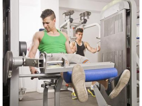 Young man doing quad exercises in gym
