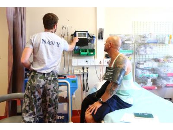 Hospital Corpsman with patient in medical room.