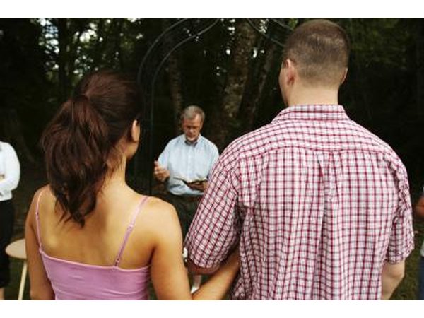 A bride and groom to be practice the ceremony with a notary outside.