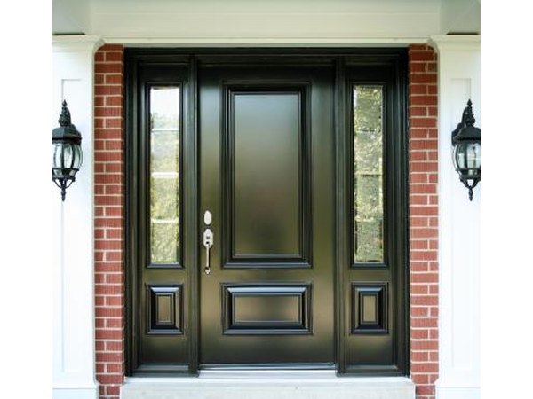 A front door painted black on a brick home.