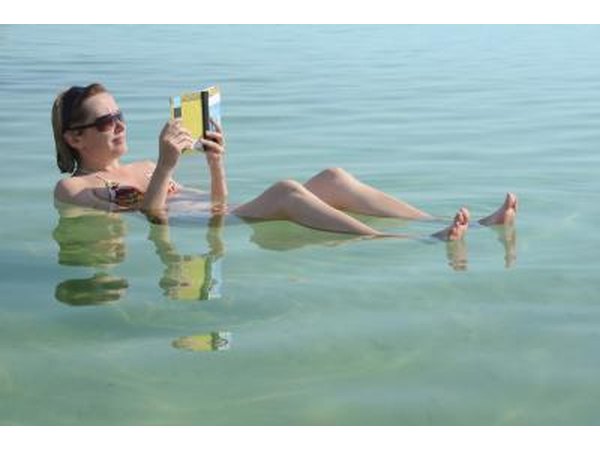 Woman reads a book while floating in the Dead Sea