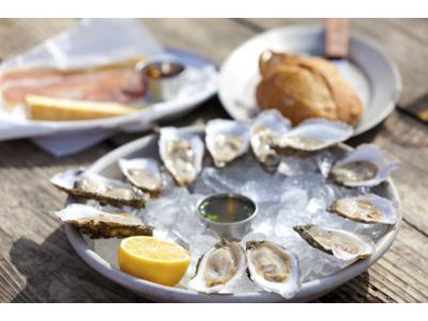 A plate of oysters with lemon on ice.