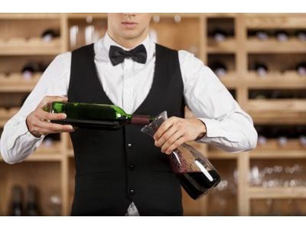Waiter in tuxedo pouring wine