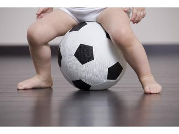 Baby sitting on a soccer ball.