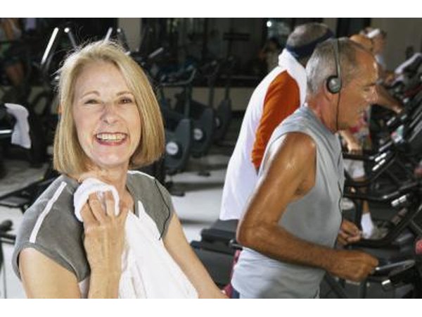 A mature woman is finishing up her workout on the treadmill.