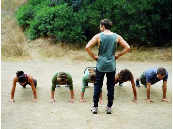 trainer and group of people doing push ups