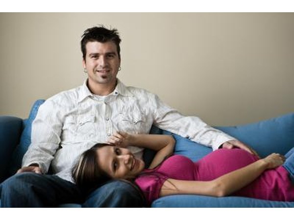 pregnant woman lying on couch with husband