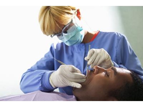 A dental hygienist cleans a patients teeth.