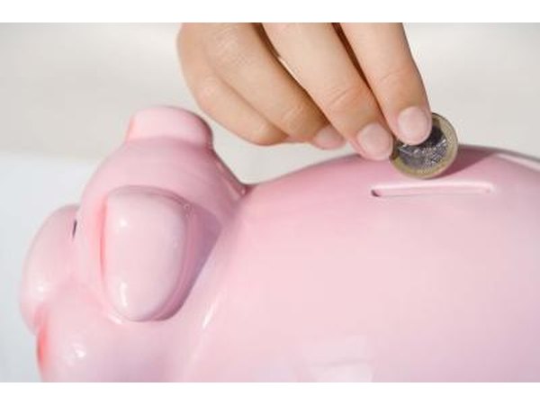 Girl putting money in piggy bank