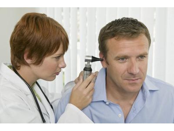 Doctor looking in man's ear
