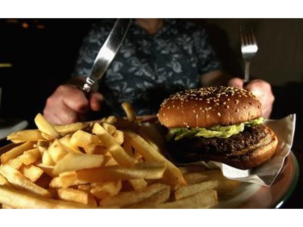 Man about to eat hamburger and plate of fries