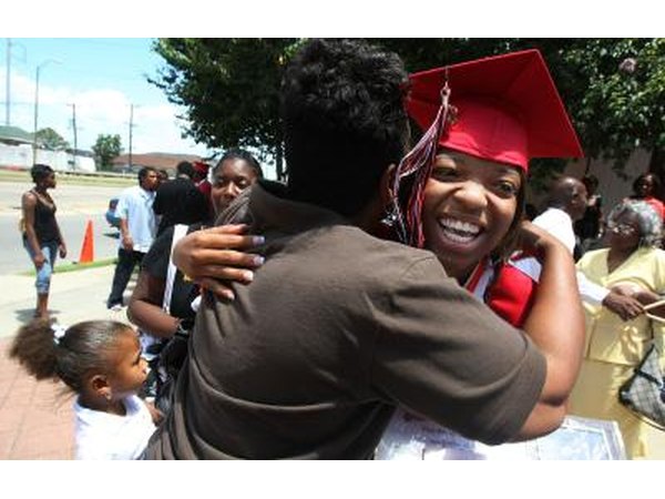 Parent hugging high school graduate