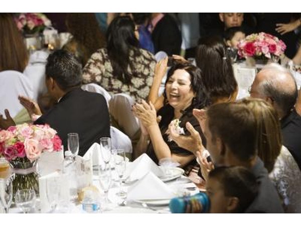 People enjoying themselves at tables in a reception hall.