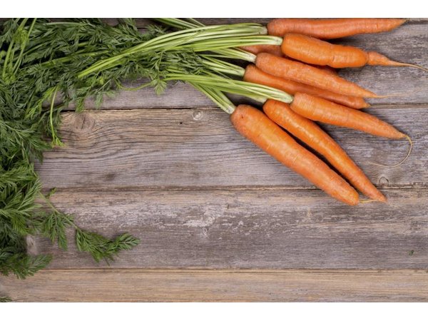 Fresh carrots on a wooden countertop.
