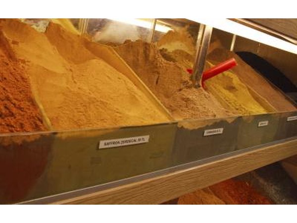 A close-up of bulk bins in a spice shop.