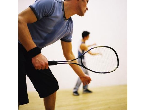 A man grips his racquet and gets ready to hit the ball.