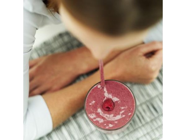 A woman drinks a fruit smoothie.