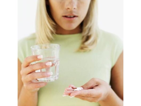 A woman takes medication for gas pain.