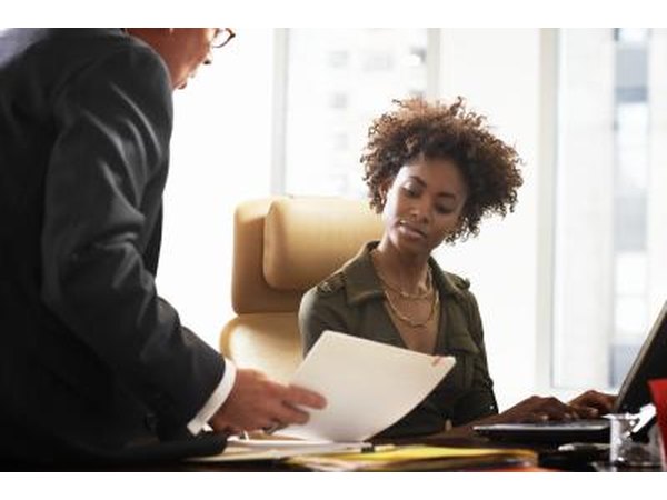 A boss speaks with an administrative assistant.