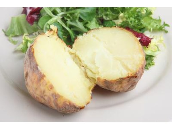A plain baked potatoe with salad.