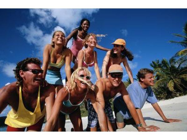 Friends making a human pyramid on the beach.