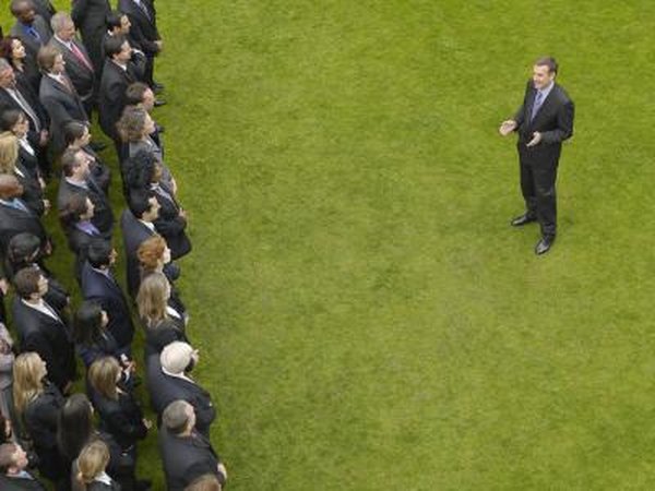 Man giving thank you speech in front of other business people on lawn