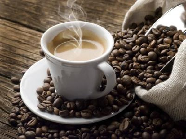 Cup of hot coffee and coffee beans on a table