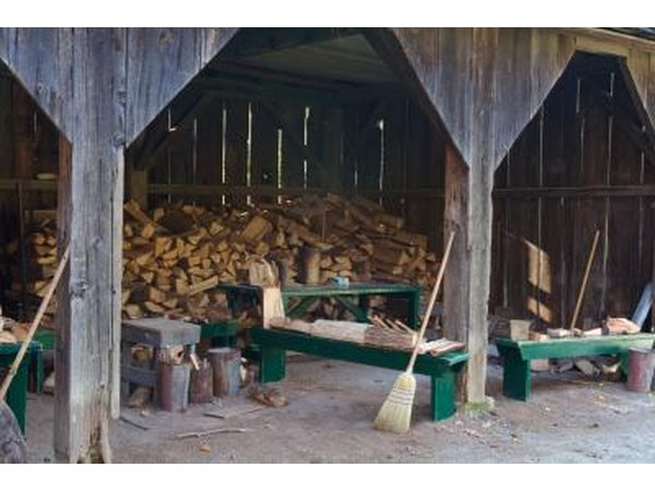 Stacks of firewood stored in a large working shed.