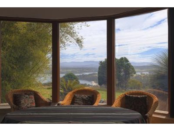 A wall of large windows in the lounge room of a cottage.