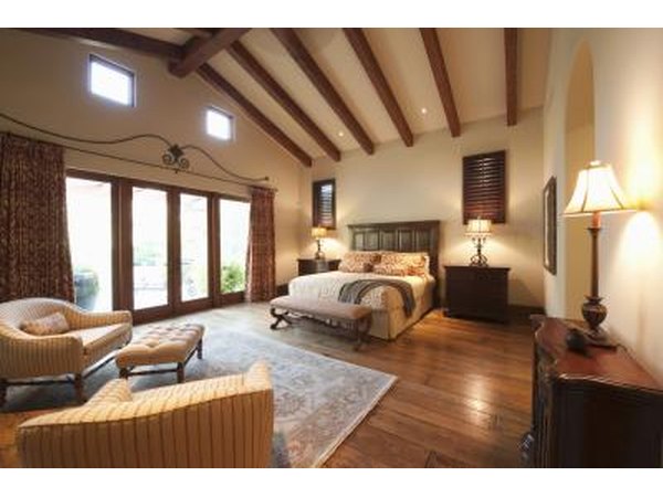 A bedroom with wood beams for support.