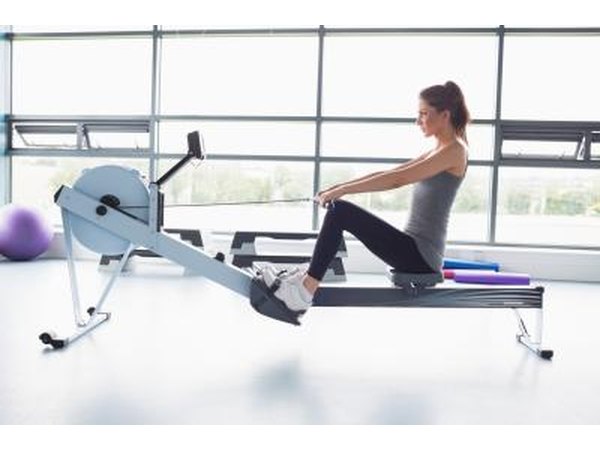A woman is using a rowing machine at the gym.