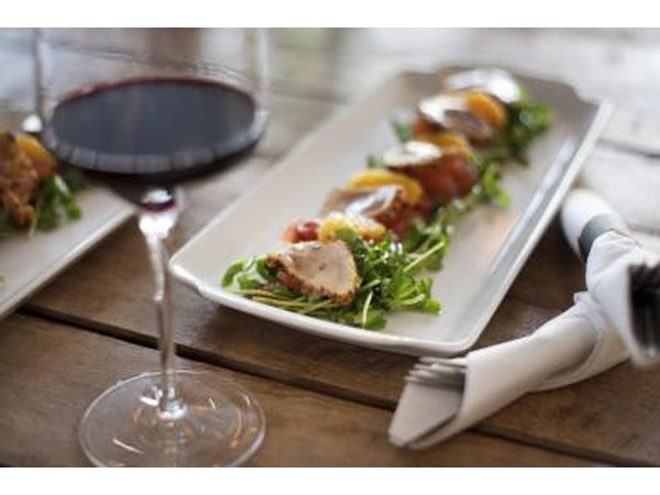 Seared fish and vegetables on a bed of fresh greens.