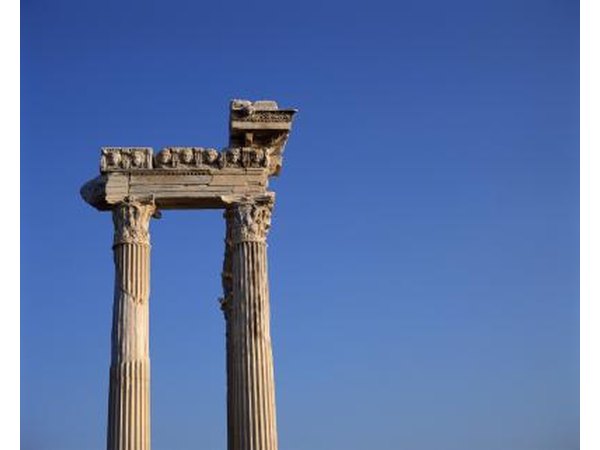 Ruins of Ionic columns surmounted by an architrave and a carved frieze piece.