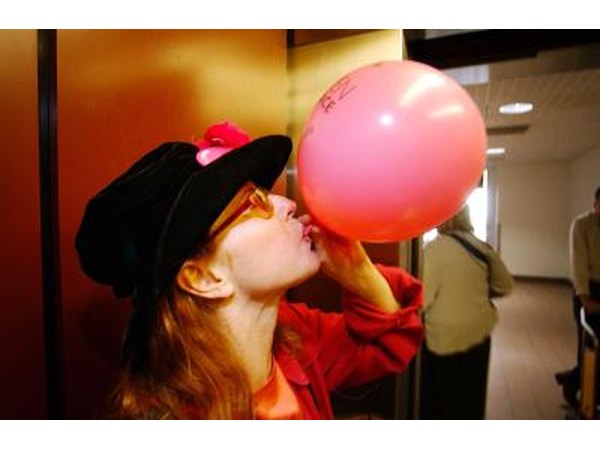 Woman blowing up pink balloon